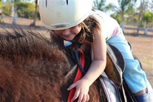Young girl hugging horse